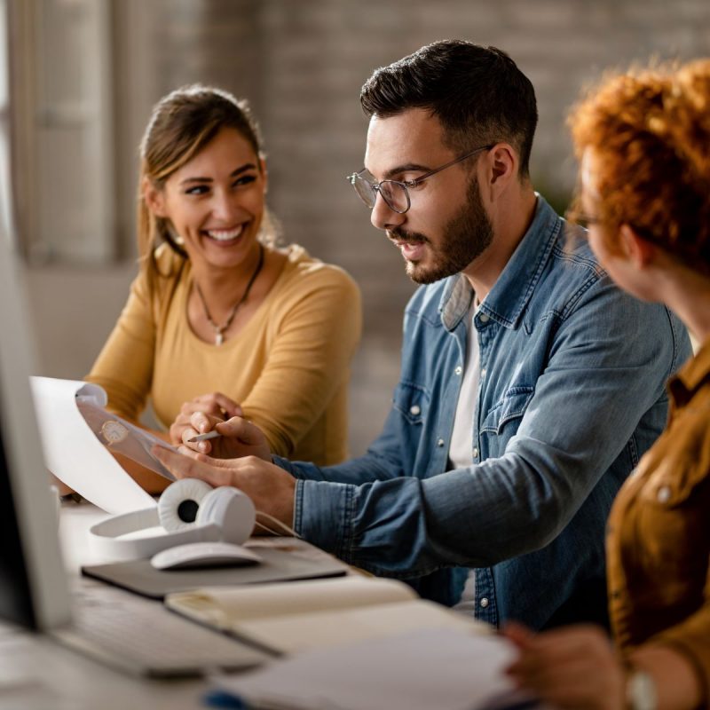 team-young-business-people-going-through-paperwork-while-working-together-office-focus-is-businessman-1.jpg